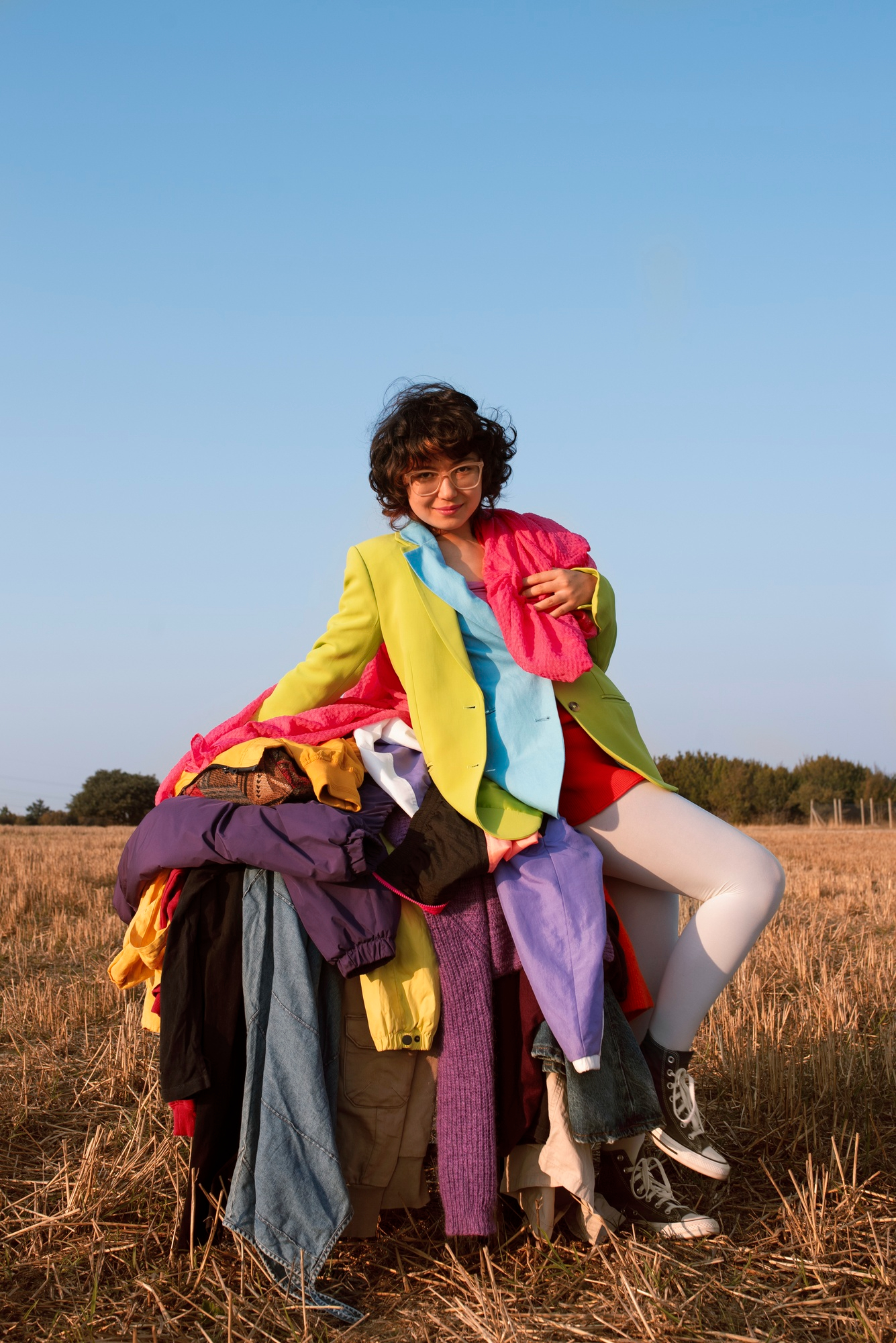Jeune femme sur pile de vêtements